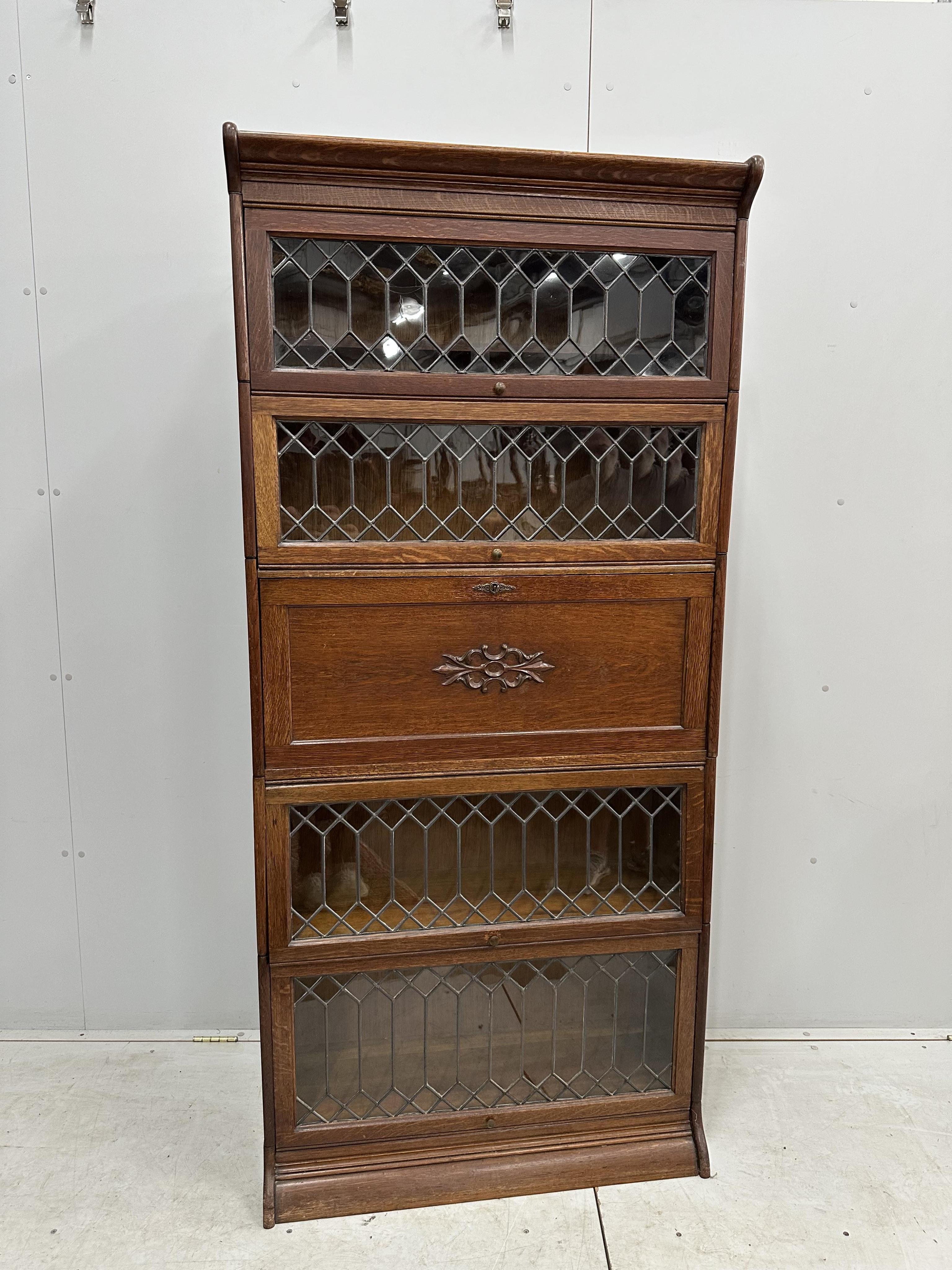 Attributed to Globe Wernicke, an oak five section bookcase incorporating secretaire compartment, width 87cm, height 190cm. Condition - good restored, back panels have been replaced